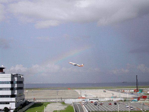 羽田空港を発着する飛行機と、虹がかかった青空